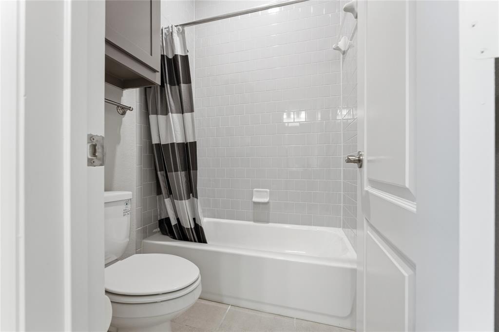 7705 Falcon Ridge Road Denton, TX 76208 - Photo 29 of 40 Bathroom featuring shower / bathtub combination with curtain and light tile patterned floors