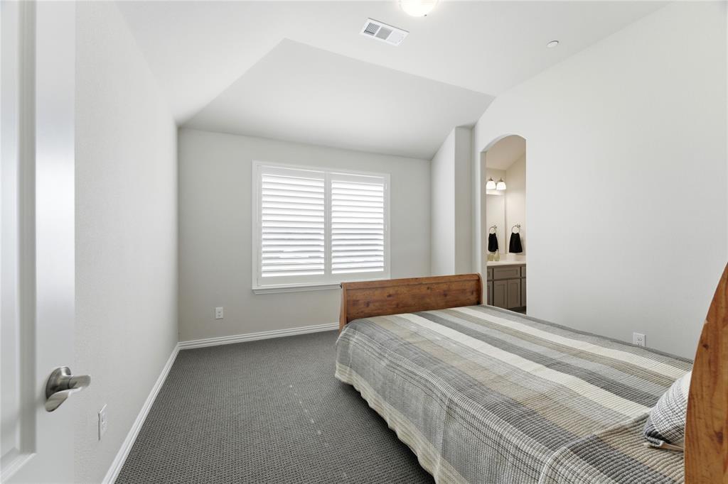7705 Falcon Ridge Road Denton, TX 76208 - Photo 32 of 40 Bedroom with dark carpet, vaulted ceiling, arched walkways, and ensuite bathroom