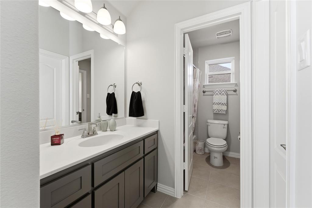 7705 Falcon Ridge Road Denton, TX 76208 - Photo 34 of 40 Full bathroom featuring vanity, a shower with curtain, and light tile patterned flooring