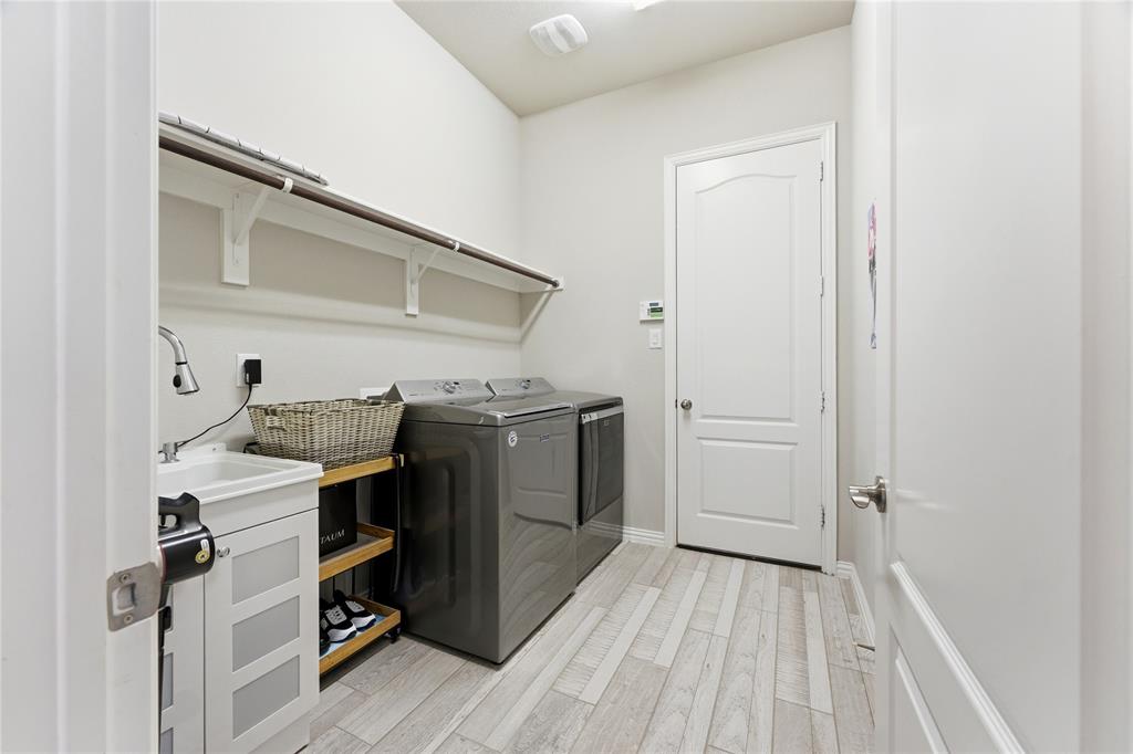 7705 Falcon Ridge Road Denton, TX 76208 - Photo 38 of 40 Laundry area featuring light wood-style floors and washing machine and dryer