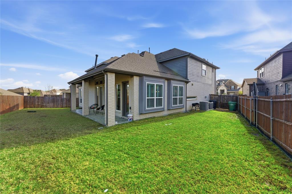 7705 Falcon Ridge Road Denton, TX 76208 - Photo 40 of 40 Back of house with a patio, a fenced backyard, and a shingled roof