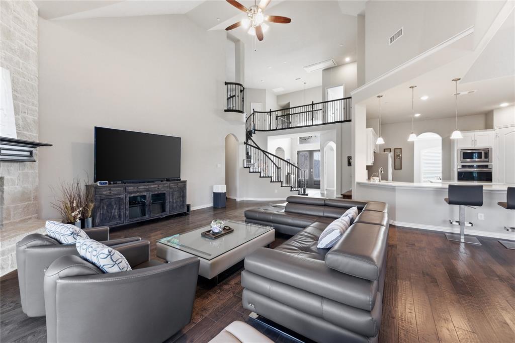 7705 Falcon Ridge Road Denton, TX 76208 - Photo 6 of 40 Living room with ceiling fan, dark wood-style floors, arched walkways, and a high ceiling