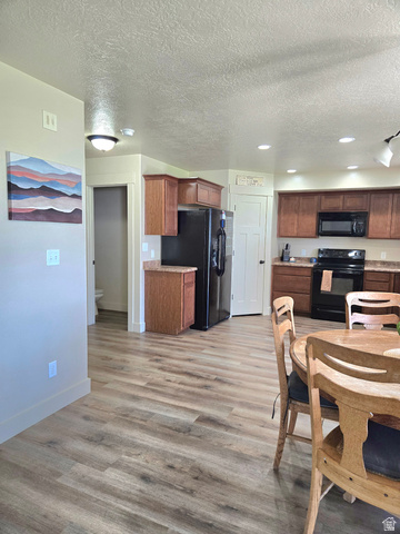 601 West 150 North, Unit 25 Springville, UT 84663 - Photo 6 of 29 Open concept kitchen and dining area featuring wood-finish flooring, recessed lighting, and a full suite of black appliances