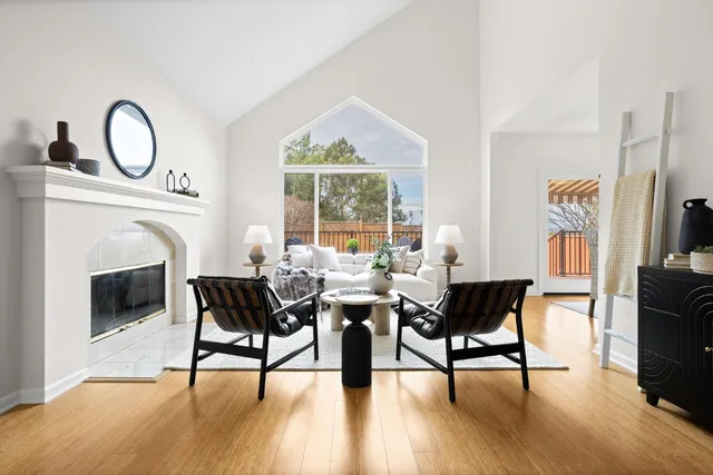a living room with furniture a fireplace and a floor to ceiling window