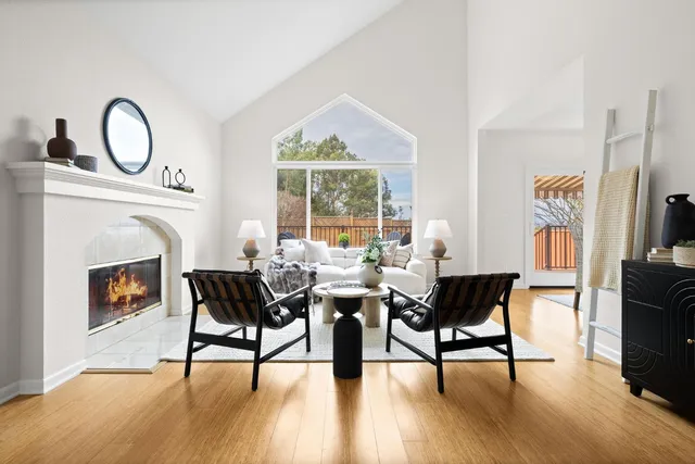 a living room with furniture a fireplace and a floor to ceiling window