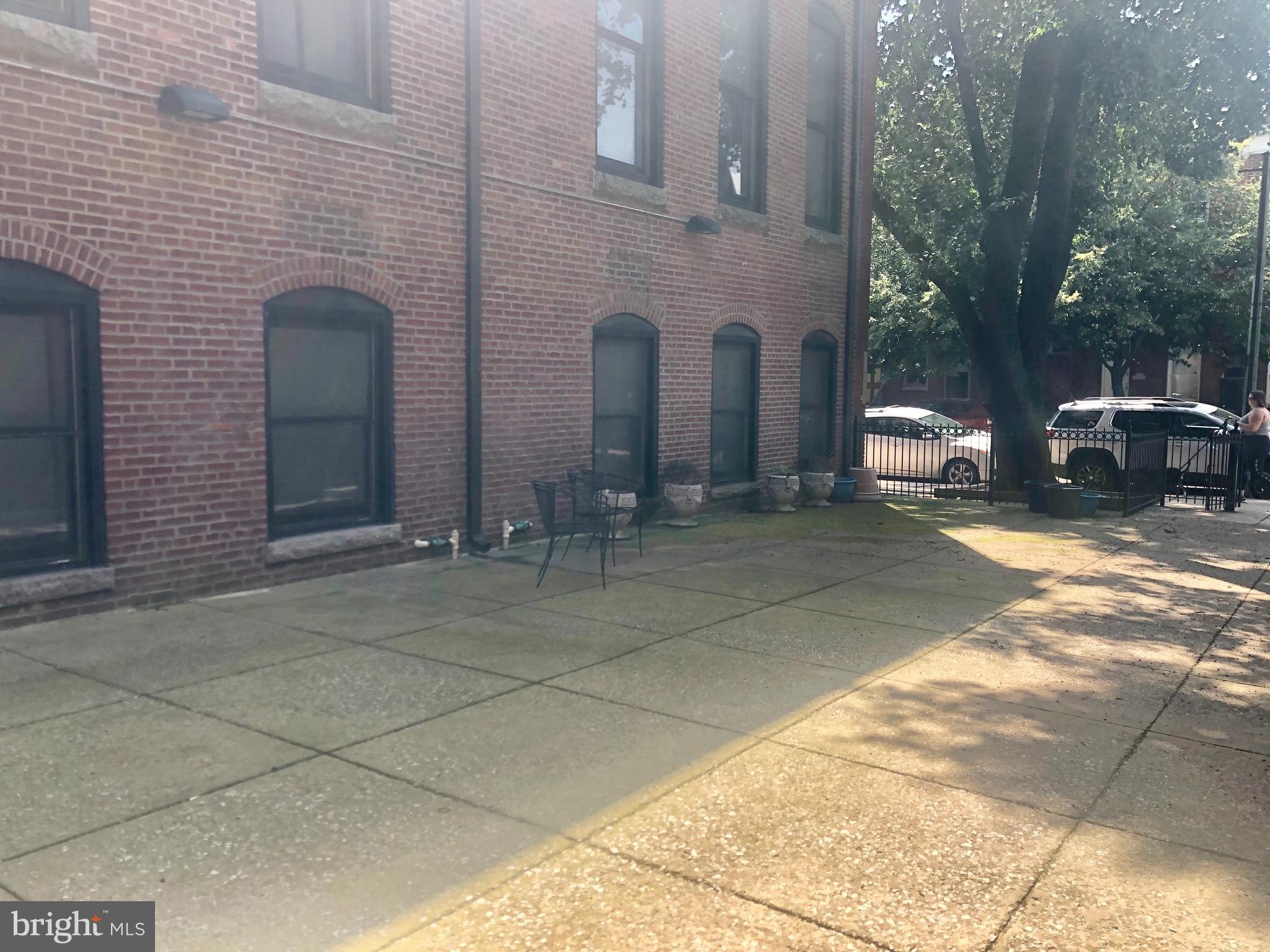 a couple of table and chairs in front of brick building