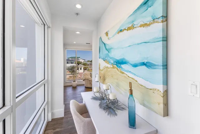 a view of a hallway with wooden floor and a window