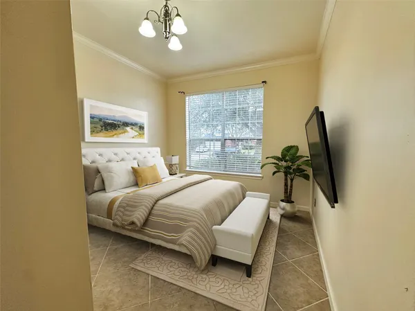 a spacious bedroom with a bed and a flat screen tv