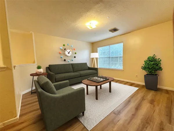 a living room with furniture wooden floor and a potted plant