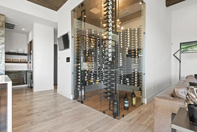 a view of a hallway with wooden floor and a bathroom