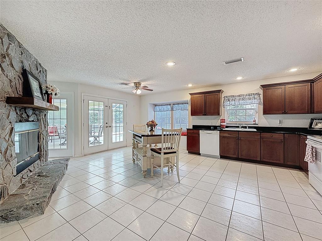 9545 Montebello Lane Spring Hill, FL 34608 - Photo 14 of 74 a open kitchen with stainless steel appliances granite countertop a stove top oven a sink dishwasher a dining table and chairs with wooden floor