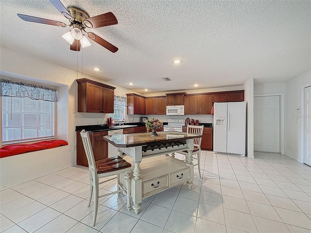 9545 Montebello Lane Spring Hill, FL 34608 - Photo 18 of 74 a kitchen with stainless steel appliances a stove a sink a dining table and chairs
