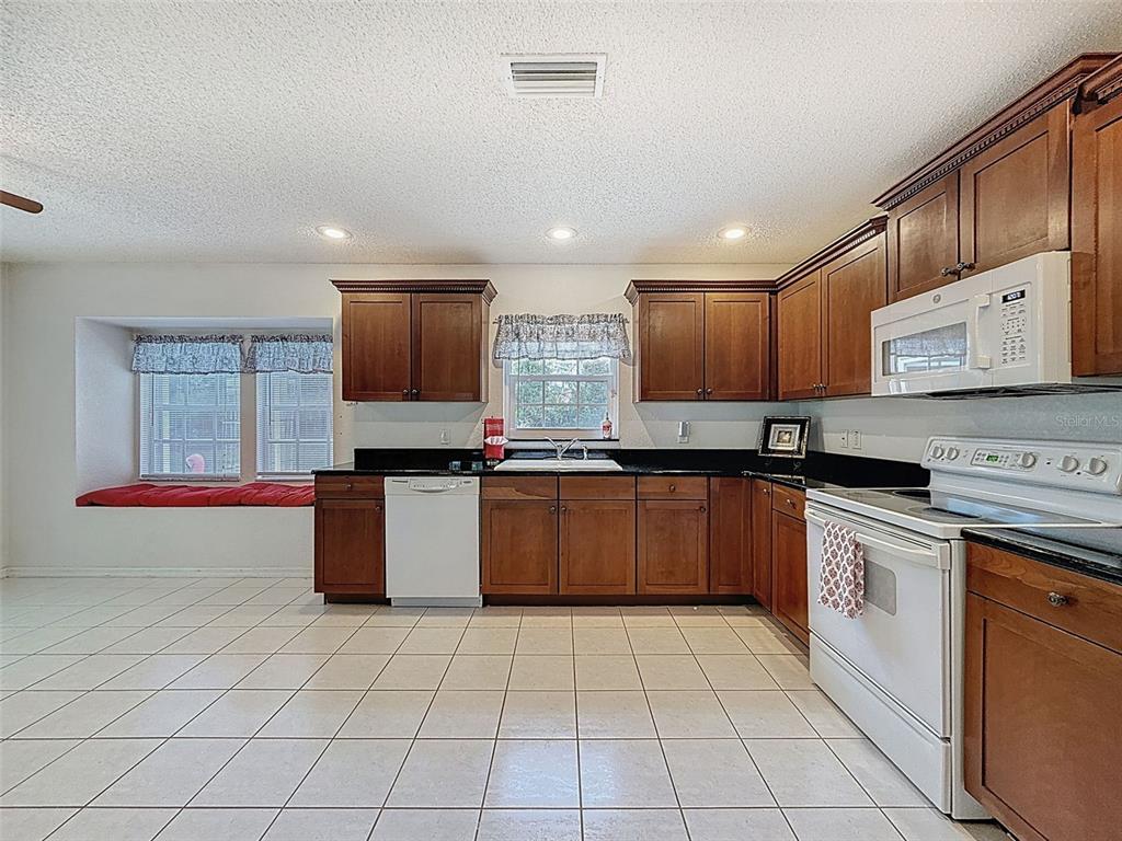 9545 Montebello Lane Spring Hill, FL 34608 - Photo 23 of 74 a kitchen with stainless steel appliances granite countertop a stove sink and cabinets