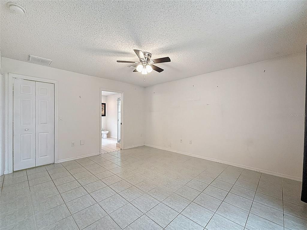9545 Montebello Lane Spring Hill, FL 34608 - Photo 27 of 74 an empty room with chandelier fan and windows