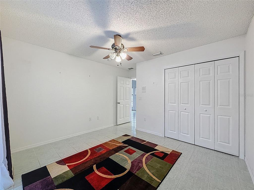 9545 Montebello Lane Spring Hill, FL 34608 - Photo 37 of 74 a bedroom with a bed and a chandelier fan