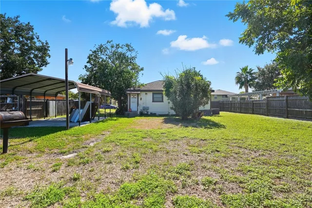 a view of a house with backyard and sitting area
