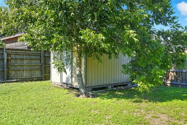a view of backyard with small cabin and wooden fence