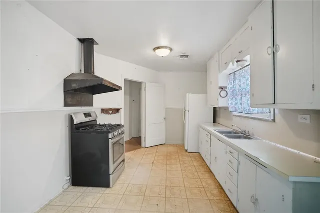 a kitchen with stainless steel appliances granite countertop a refrigerator and a stove