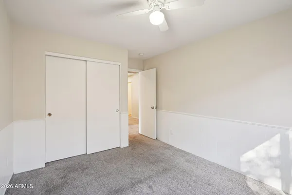 an empty room with a window and a ceiling fan