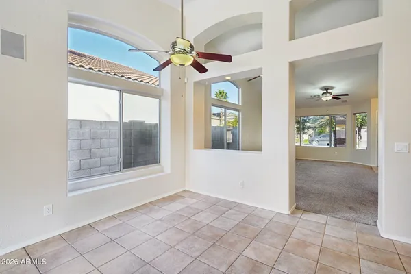 an empty room with windows and fan