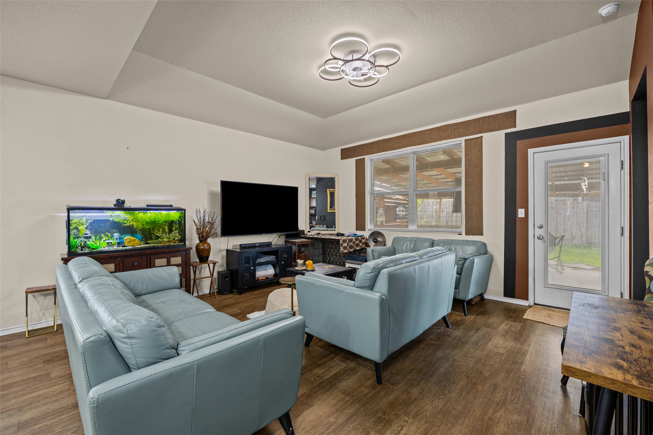 19113 Rookery Trail Pflugerville, TX 78660 - Photo 8 of 36 Living area featuring wood-finish flooring, a tray ceiling, and a modern ceiling light fixture