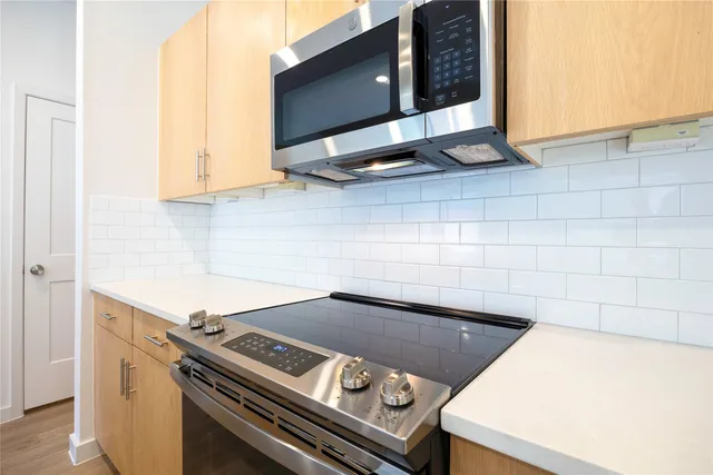 a kitchen with stainless steel appliances granite countertop a stove microwave and sink