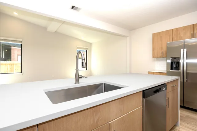 a kitchen with stainless steel appliances granite countertop a sink and a window