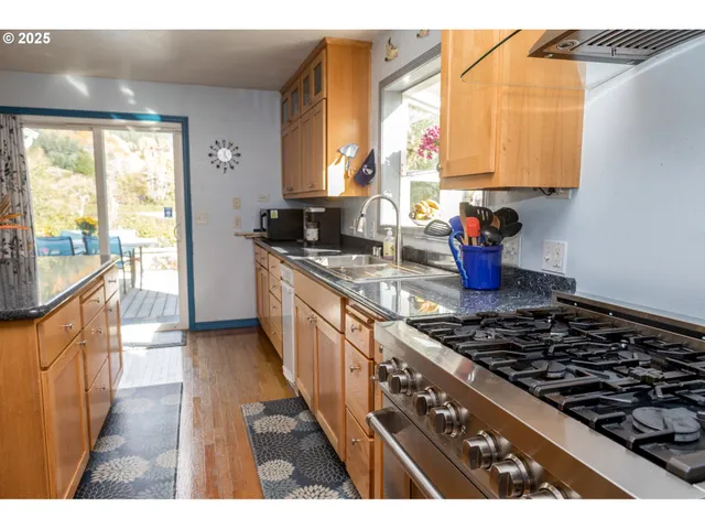 a dining table with a large window and kitchen view