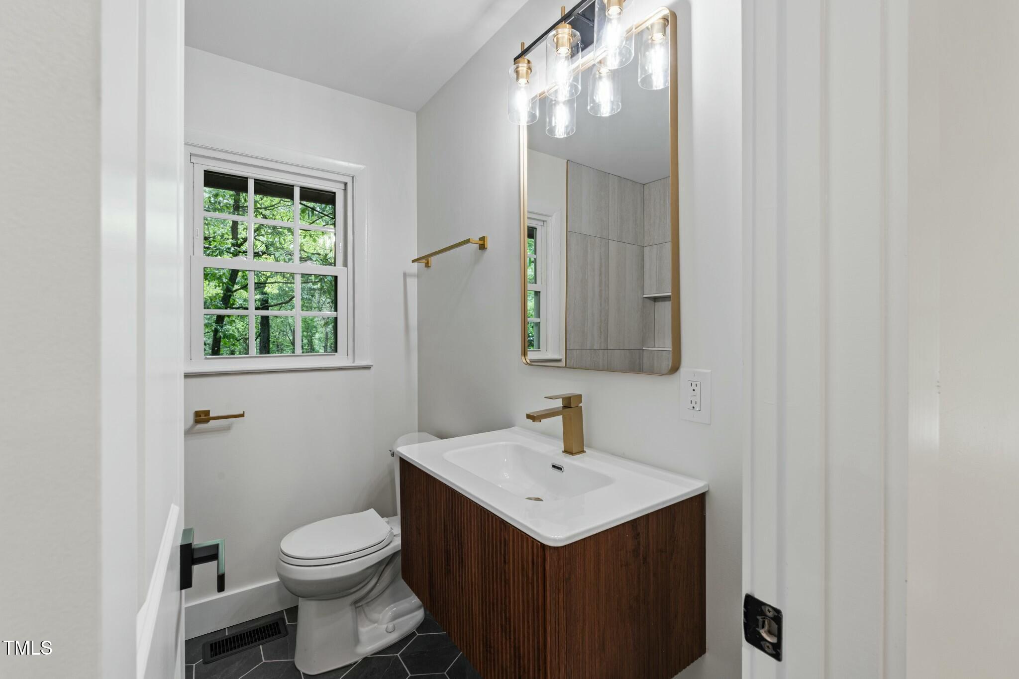 6421 Arrington Road Raleigh, NC 27607 - Photo 12 of 31 a bathroom with a sink a toilet and mirror