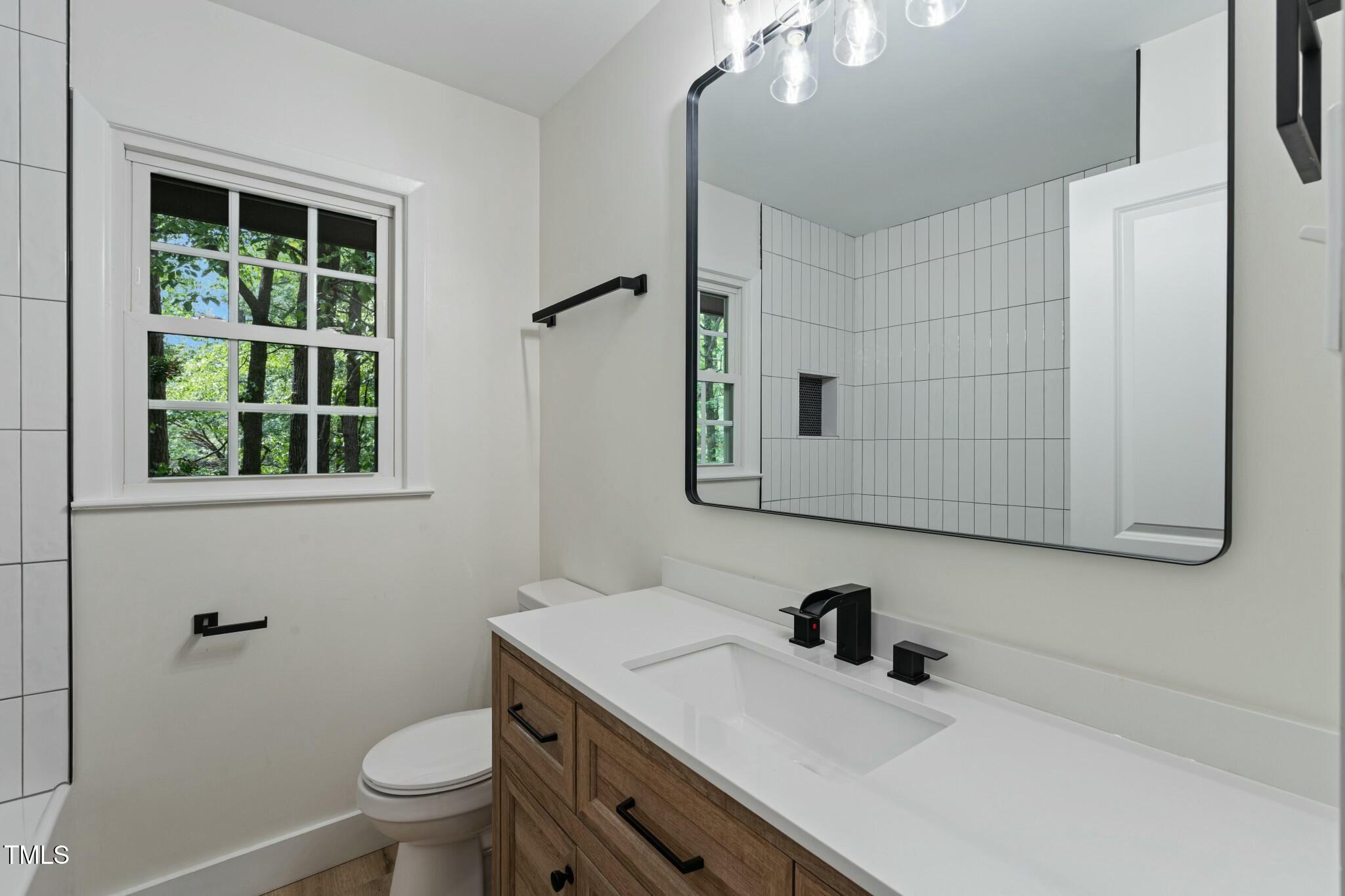 6421 Arrington Road Raleigh, NC 27607 - Photo 17 of 31 a bathroom with a sink a toilet and a mirror