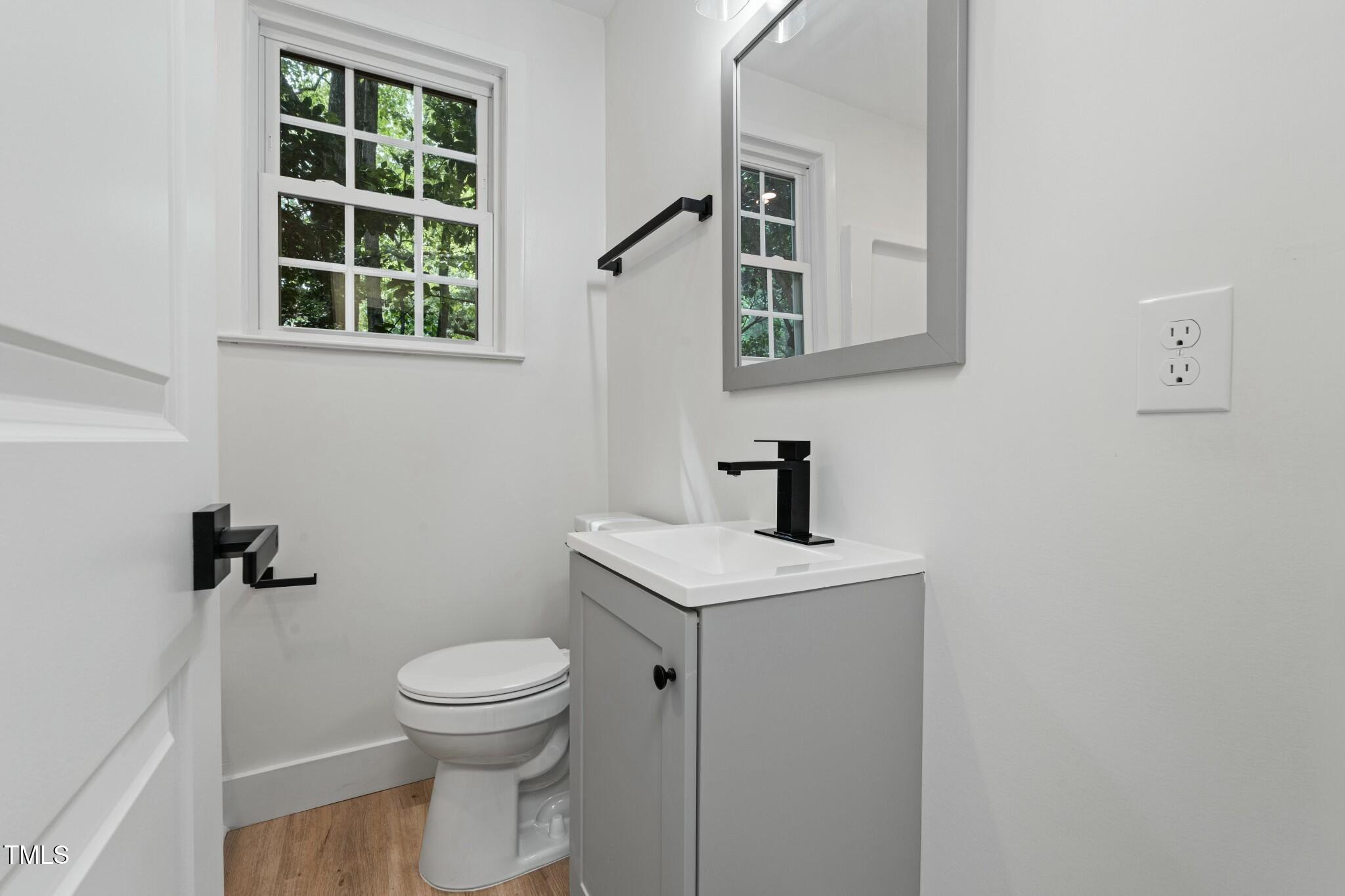6421 Arrington Road Raleigh, NC 27607 - Photo 21 of 31 a bathroom with a toilet a sink and a window