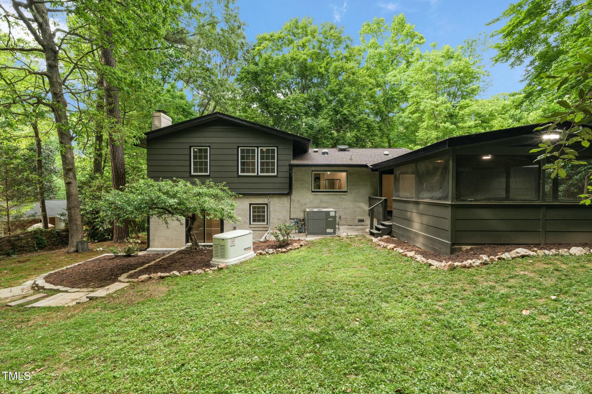 6421 Arrington Road Raleigh, NC 27607 - Photo 27 of 31 a backyard of a house with table and chairs under an umbrella