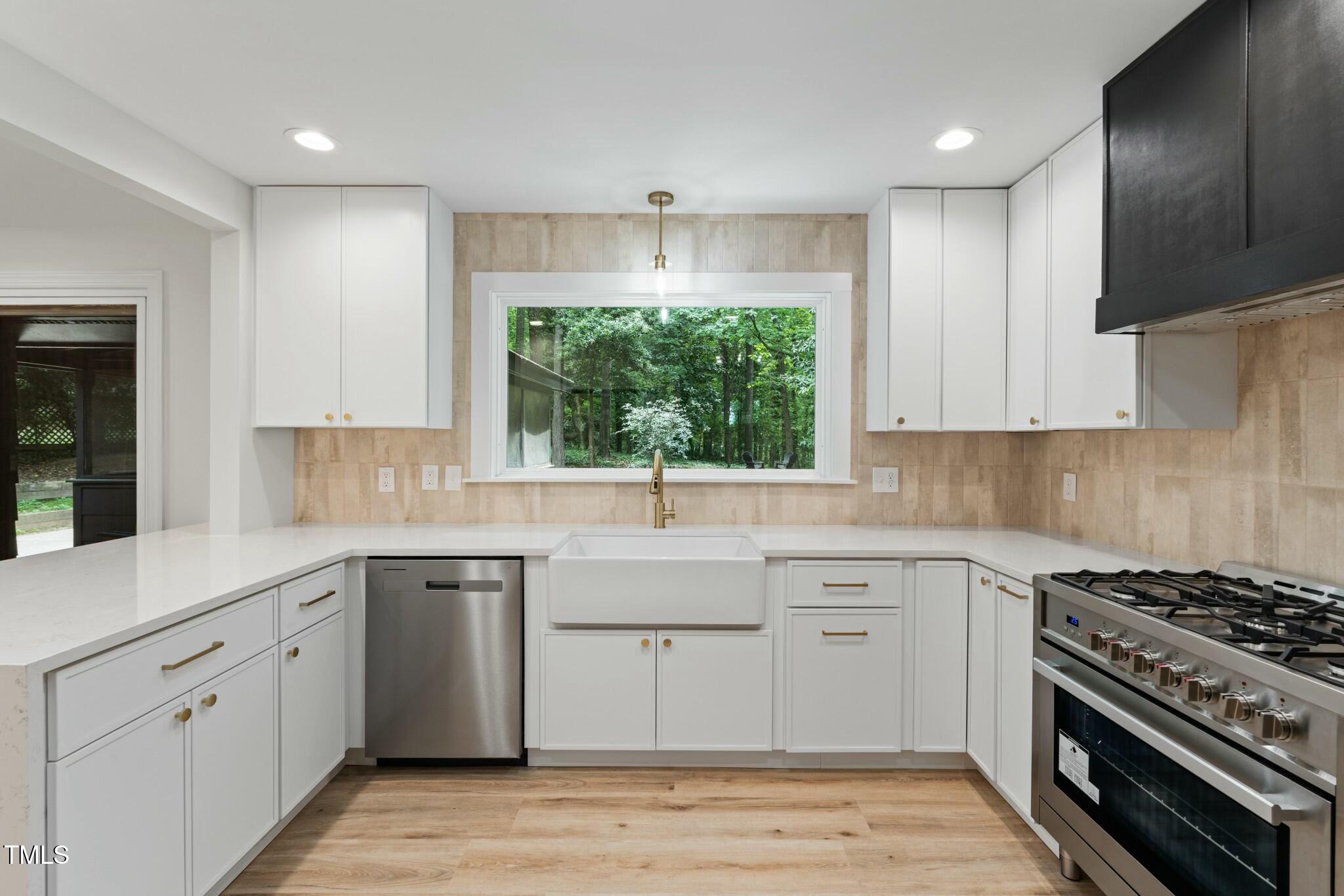 6421 Arrington Road Raleigh, NC 27607 - Photo 3 of 31 a kitchen with a sink stove and cabinets