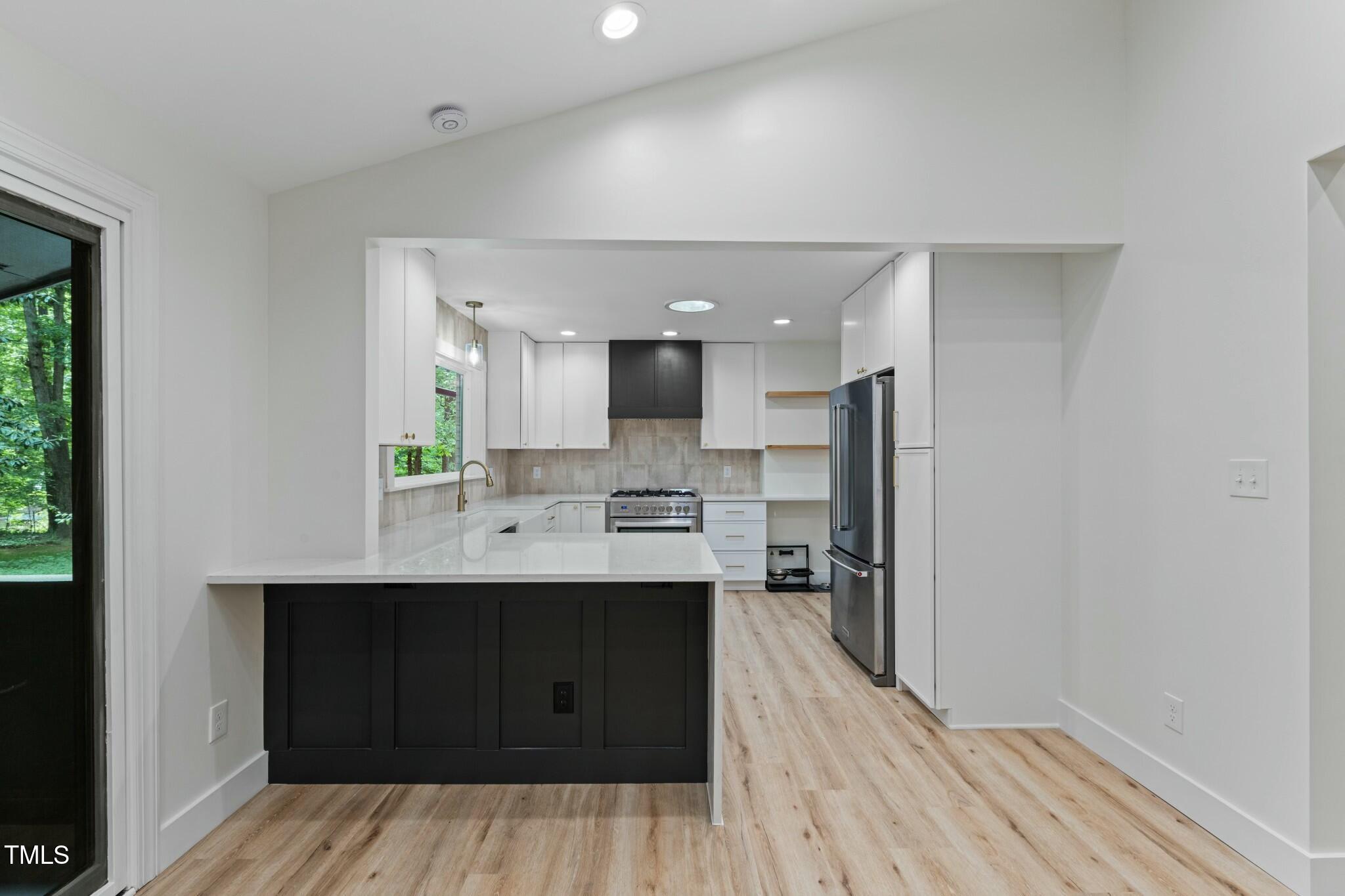 6421 Arrington Road Raleigh, NC 27607 - Photo 4 of 31 a kitchen with stainless steel appliances a sink cabinets and wooden floor