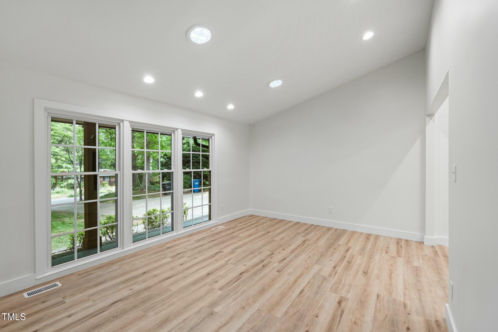6421 Arrington Road Raleigh, NC 27607 - Photo 9 of 31 a view of empty room with wooden floor and fan