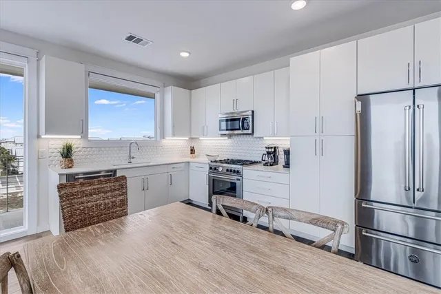 a kitchen with a refrigerator stove and white cabinets