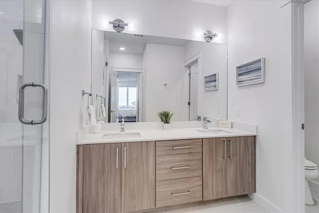a bathroom with a double vanity sink mirror and shower