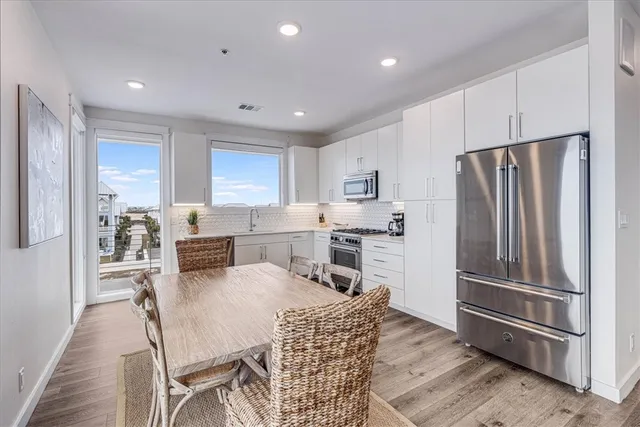 a kitchen with stainless steel appliances granite countertop a refrigerator microwave and wooden cabinets