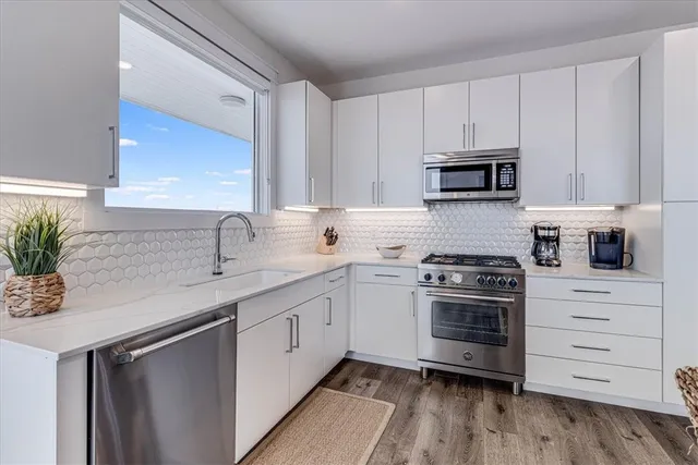 a kitchen with appliances a sink and cabinets