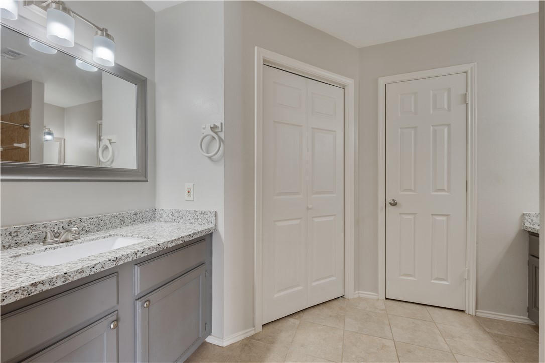 1003 East 24th Street Bryan, TX 77803 - Photo 13 of 24 Bathroom featuring vanity, light tile patterned floors, and a closet