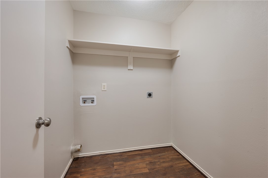 1003 East 24th Street Bryan, TX 77803 - Photo 17 of 24 Laundry room with dark wood-type flooring, hookup for an electric dryer, hookup for a washing machine, and a textured ceiling