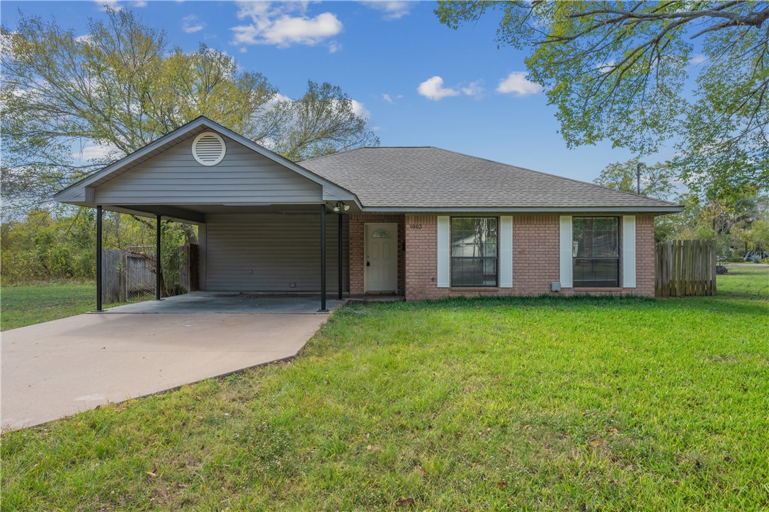 1003 East 24th Street Bryan, TX 77803 - Photo 2 of 24 Ranch-style home with an attached carport, brick siding, concrete driveway, and a shingled roof