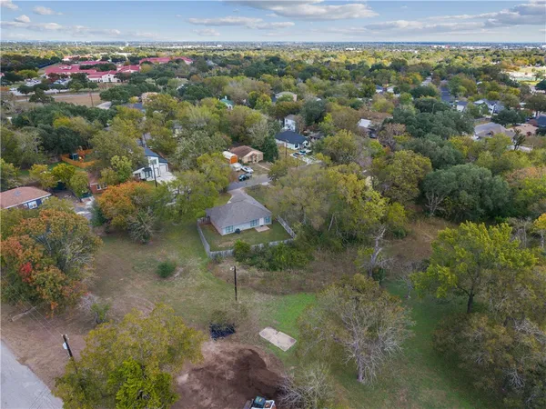 an aerial view of residential houses with outdoor space and trees