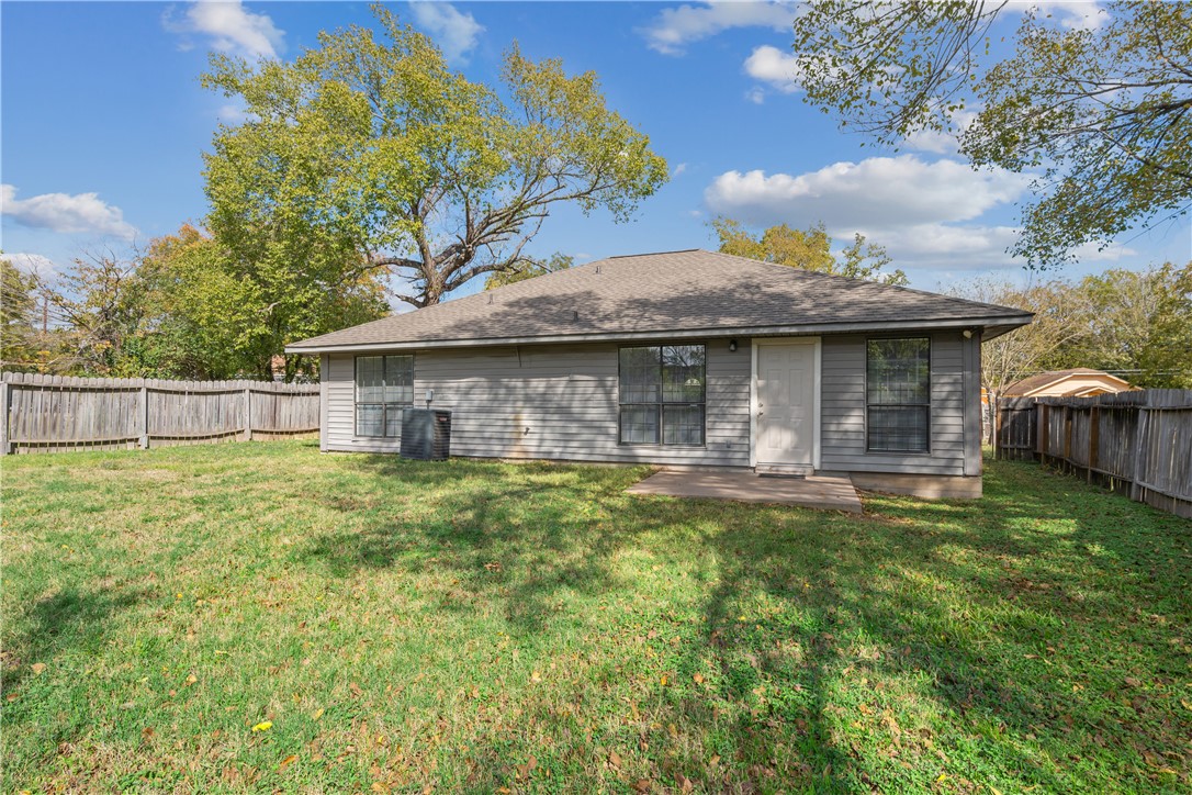 1003 East 24th Street Bryan, TX 77803 - Photo 21 of 24 Rear view of house with a fenced backyard, a patio area, and roof with shingles