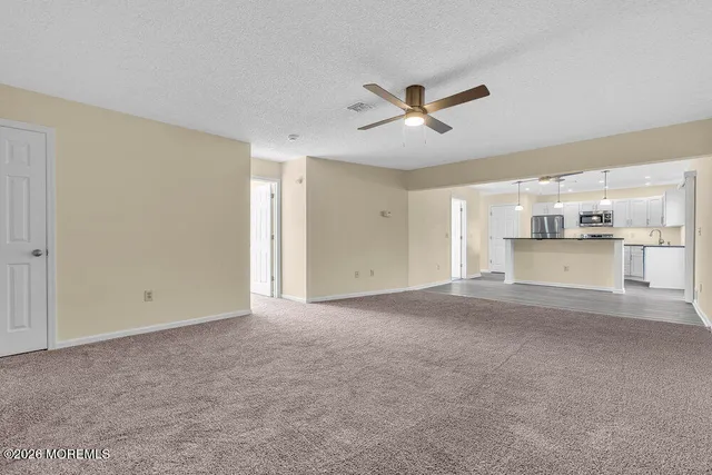 a view of kitchen with stainless steel appliances granite countertop cabinets and wooden floor