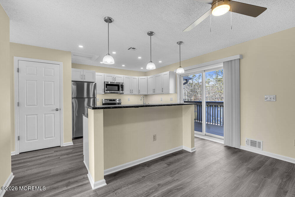 290 North Main Street, Unit C4 Barnegat, NJ 08005 - Photo 4 of 12 a view of kitchen with stainless steel appliances granite countertop cabinets and wooden floor