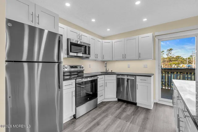 a kitchen with kitchen island a sink stainless steel appliances and cabinets