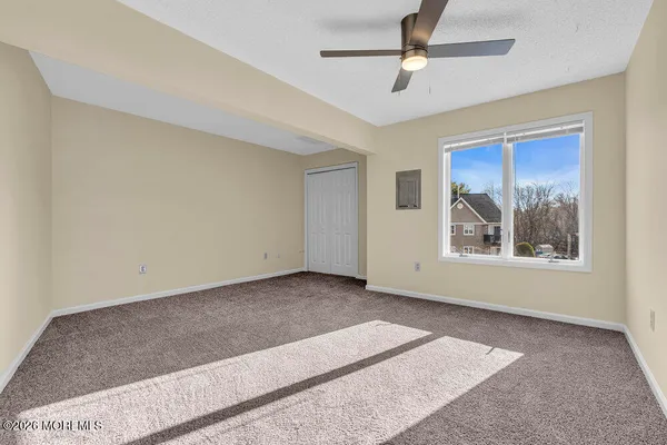 a view of a big room with wooden floor and a ceiling fan