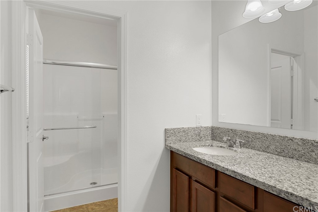29309 First Green Lake Elsinore, CA 92530 - Photo 24 of 59 a bathroom with a granite countertop sink and a mirror