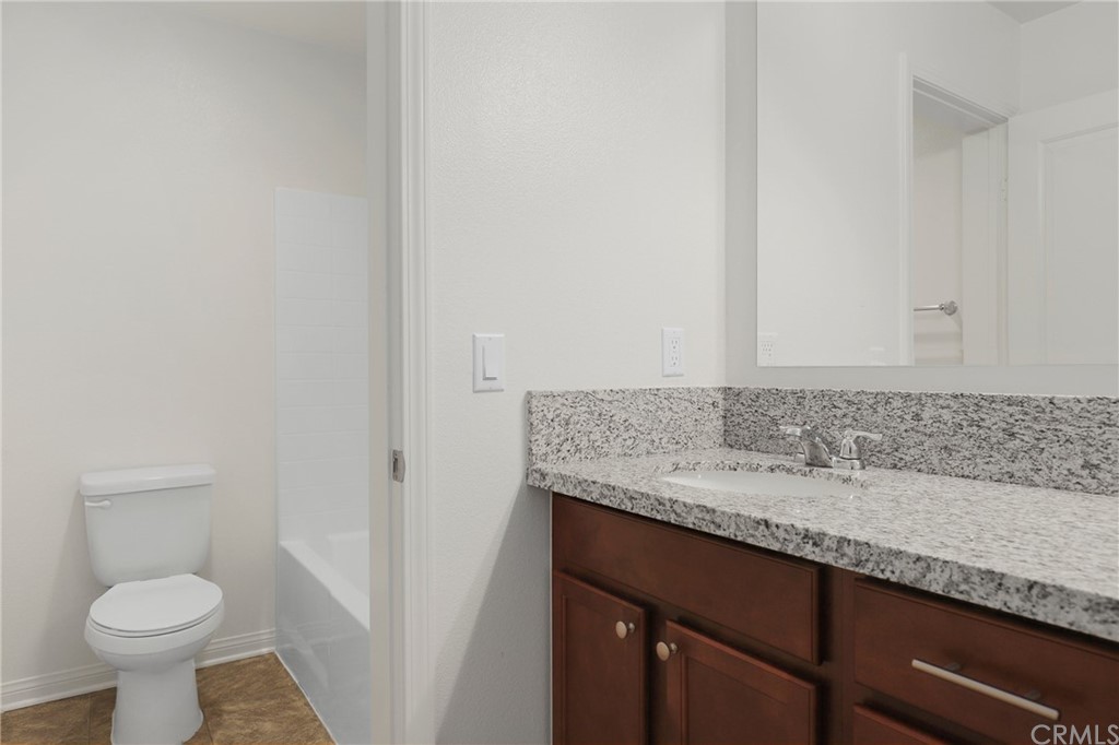 29309 First Green Lake Elsinore, CA 92530 - Photo 27 of 59 a bathroom with a granite countertop sink and a toilet